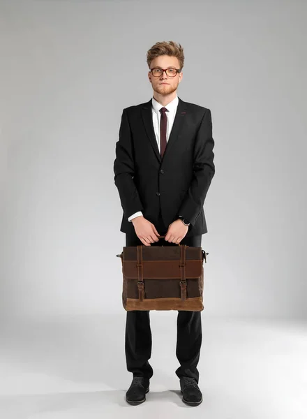 Handsome businessman with stylish briefcase on light background — Stock Photo, Image