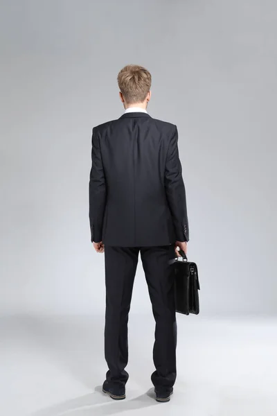 Jóképű üzletember, elegáns táska-ra könnyű háttér, hátsó nézet — Stock Fotó