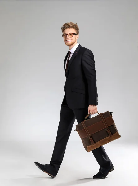 Going businessman with stylish briefcase on light background — Stock Photo, Image