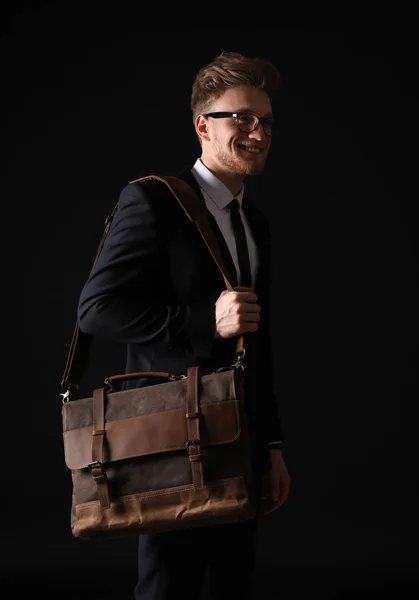 Handsome businessman with stylish briefcase on dark background — Stock Photo, Image