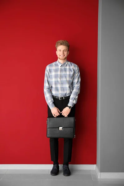 Handsome man with stylish briefcase near color wall — Stock Photo, Image