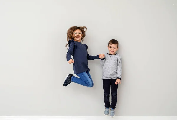 Niños pequeños saltando sobre fondo blanco — Foto de Stock