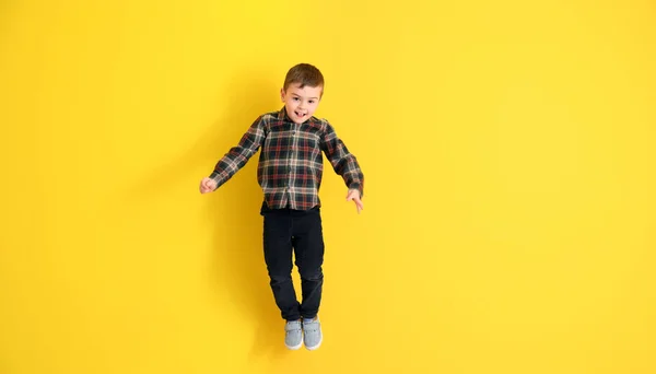 Saltando menino no fundo da cor — Fotografia de Stock