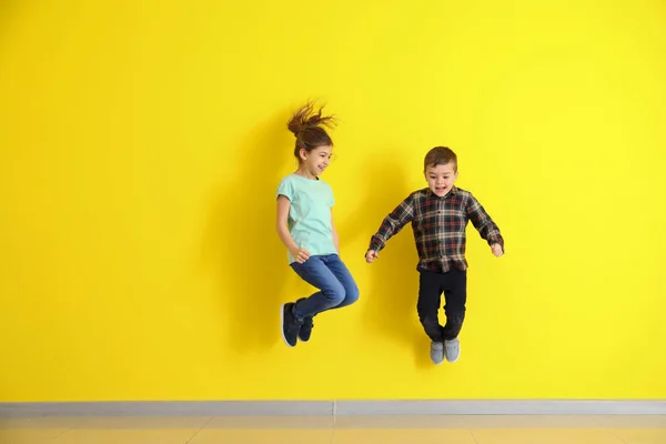 Saltar a los niños pequeños en el fondo de color — Foto de Stock