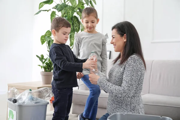 Family sorting garbage at home. Concept of recycling