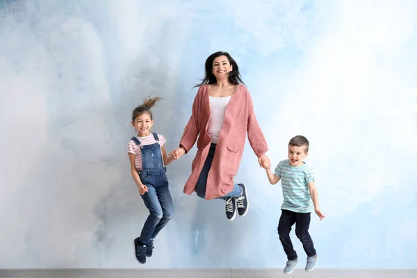 Feliz familia de salto sobre fondo de color — Foto de Stock