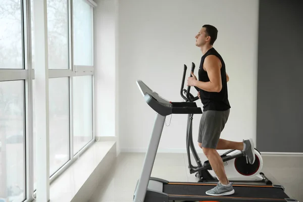 Sportig ung man på löpbandet i gymmet — Stockfoto