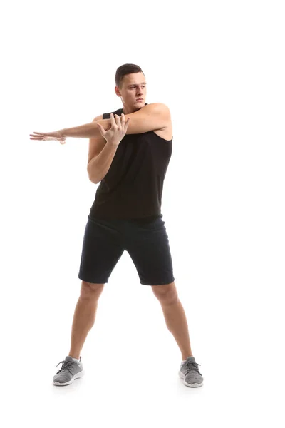 Sportlicher junger Mann beim Training vor weißem Hintergrund — Stockfoto