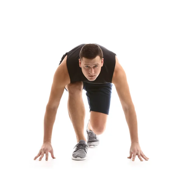 Sporty young man in crouch start position against white background — Stock Photo, Image