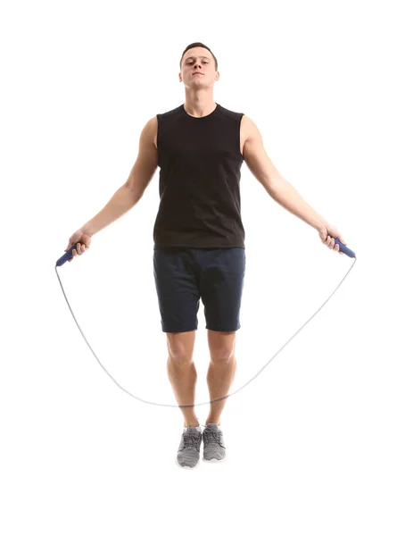 Sporty young man jumping rope against white background — Stock Photo, Image