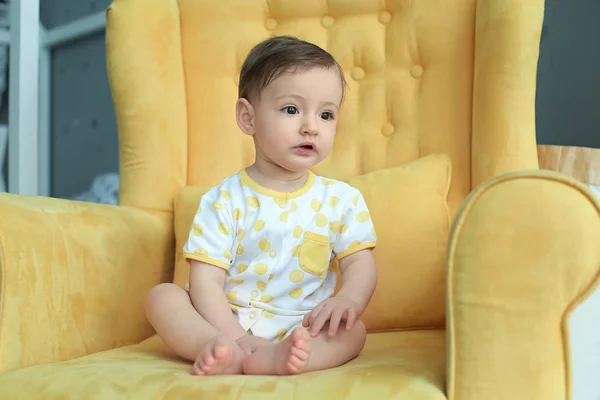 Cute baby girl sitting in armchair — Stock Photo, Image