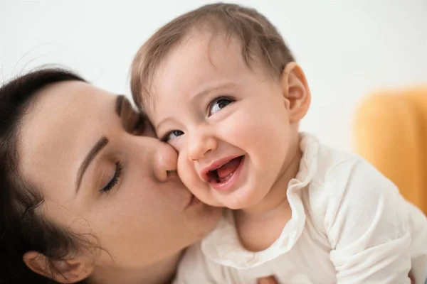 Madre baciare il suo piccolo bambino carino a casa — Foto Stock