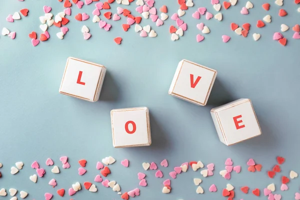 Palabra AMOR compuesta de cubos y corazones de color sobre fondo gris. Celebración de San Valentín — Foto de Stock