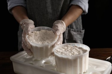 Koyu arka plan, closeup lezzetli peynir hazırlama kadın