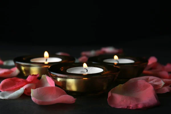 Зажигание свечей с лепестками цветов для празднования Дивали на тёмном фоне — стоковое фото
