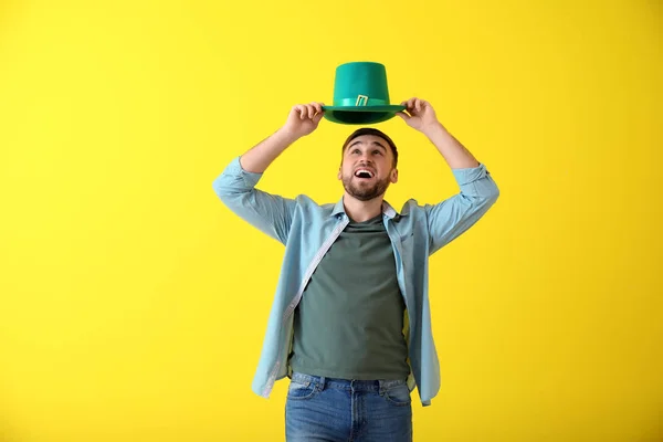 Joven guapo con sombrero verde sobre fondo de color. Celebración del Día de San Patricio — Foto de Stock