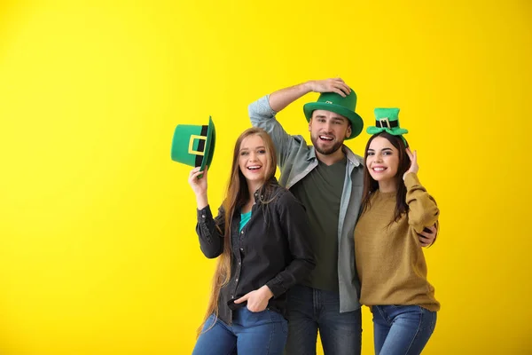 Young people in green hats on color background. St. Patrick's Day celebration — Stock Photo, Image