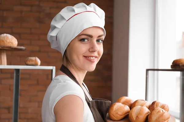 Vrouwelijke chef-kok met versgebakken broodjes in keuken — Stockfoto