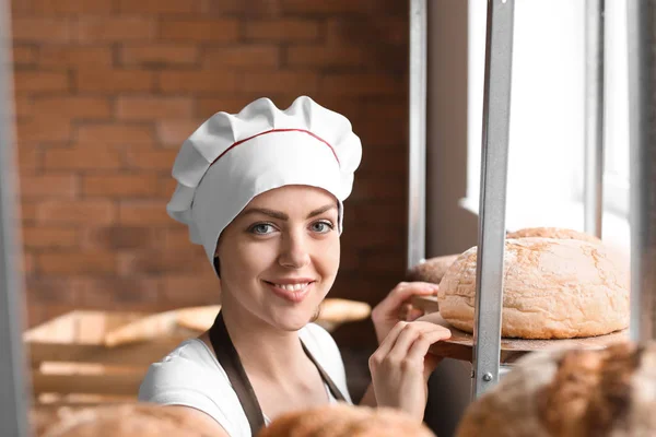 Vrouwelijke chef-kok met vers gebakken brood in keuken — Stockfoto