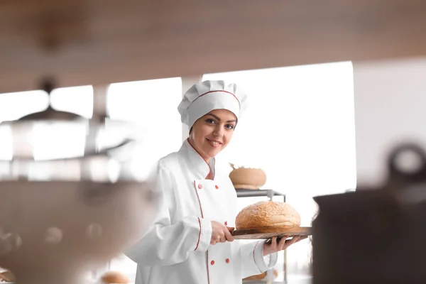 Female chef with freshly baked bread in kitchen — Stock Photo, Image