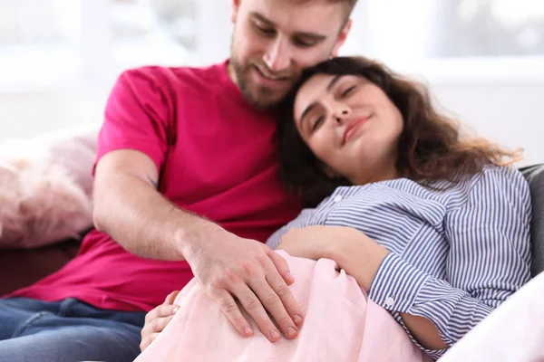 Lykkelig gravid par hviler derhjemme - Stock-foto