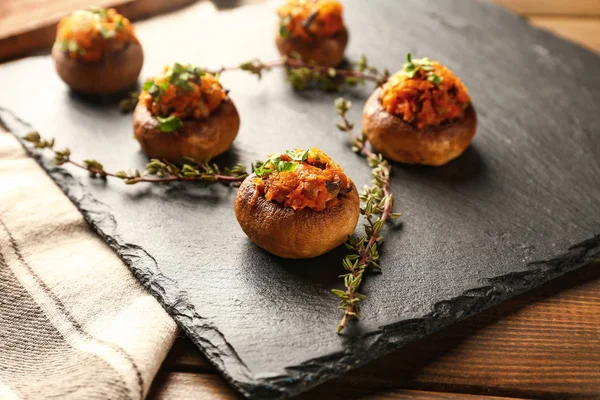 Leisteen plaat met lekkere gevulde champignons op tafel — Stockfoto