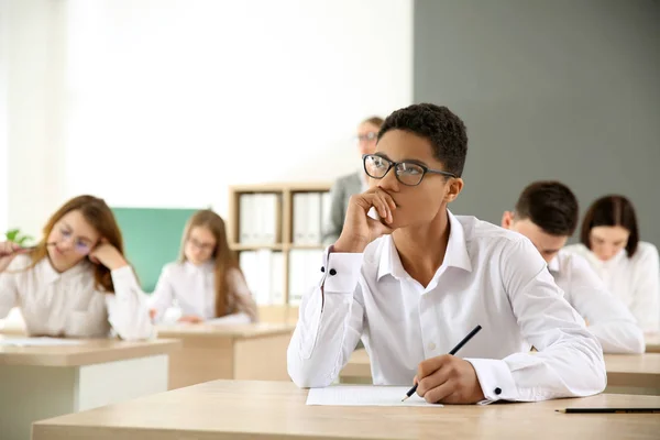 Menino afro-americano durante teste escolar em sala de aula — Fotografia de Stock