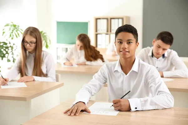 Pupils passing school test in classroom — Stock Photo, Image