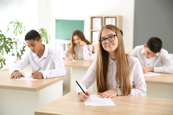 Pupils passing school test in classroom — Stock Photo, Image