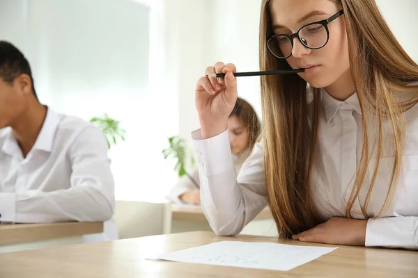 Girl passing school test in classroom — Stock Photo, Image