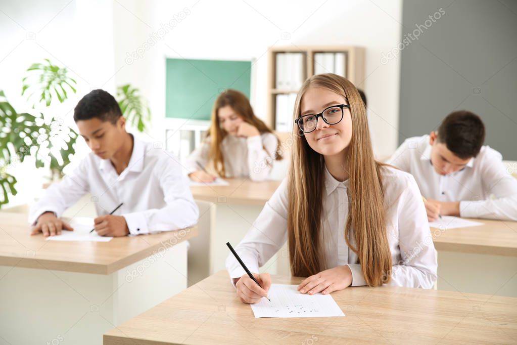 Pupils passing school test in classroom