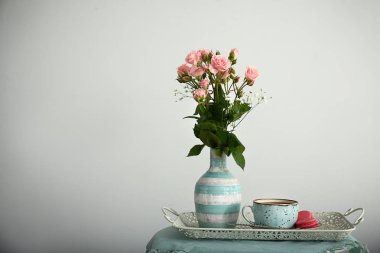 Kahve, kek ve açık renkli karşı masaya güzel çiçek fincan ile tepsi