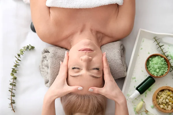 Mature woman receiving face massage in beauty salon — Stock Photo, Image