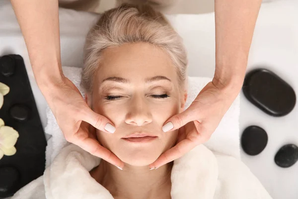 Mature woman receiving face massage in beauty salon — Stock Photo, Image