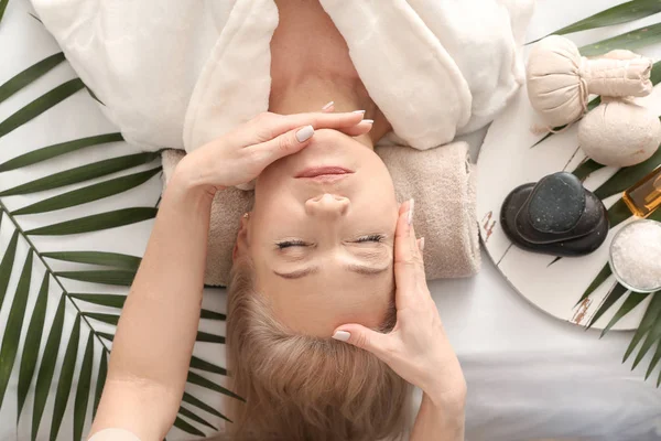 Mature woman receiving face massage in beauty salon — Stock Photo, Image