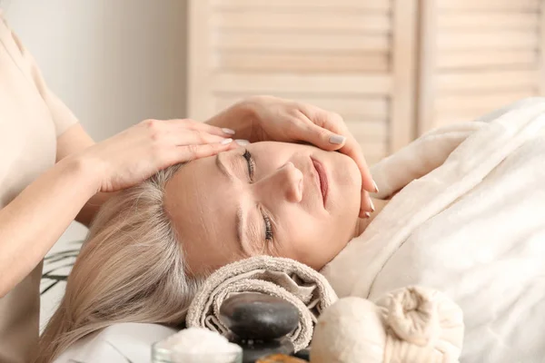 Mature woman receiving face massage in beauty salon — Stock Photo, Image