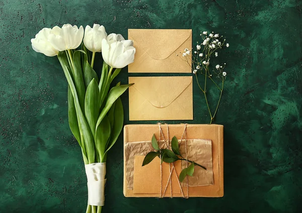 Boeket van mooie tulpen, geschenken en enveloppen op kleur achtergrond — Stockfoto