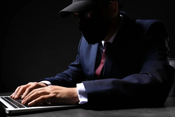 Hacker profissional com laptop sentado à mesa — Fotografia de Stock
