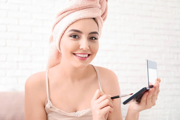 Jovem mulher após o banho aplicando cosméticos no rosto em casa — Fotografia de Stock