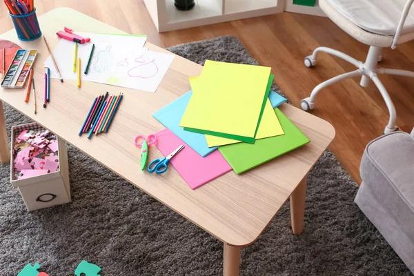 Wooden table with stationery in kid room — Stock Photo, Image
