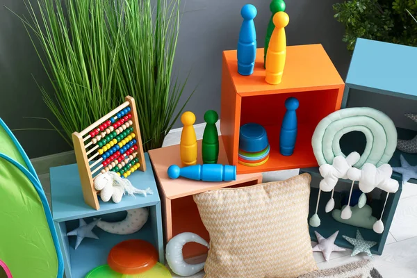Estantes con juguetes y almohada suave en habitación para niños — Foto de Stock