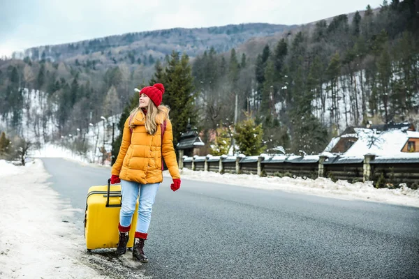 Woman with suitcase at winter resort — Stock Photo, Image