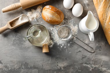 Ekmek yapım ürünleri ile oklava ve gri arka plan üzerinde hamur için malzemeler