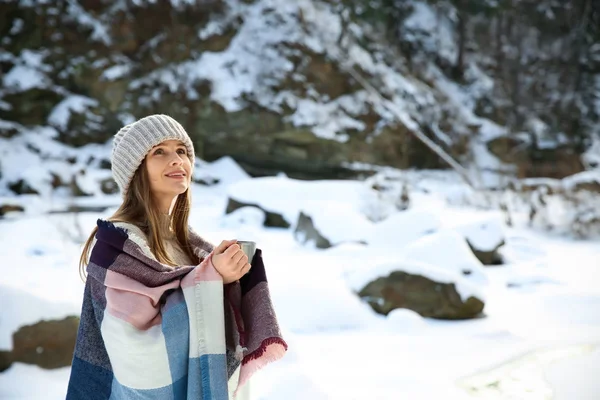 Beautiful woman with cup of hot mulled wine at snowy resort — Stock Photo, Image