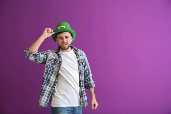 Joven guapo con sombrero verde sobre fondo de color. Celebración del Día de San Patricio — Foto de Stock