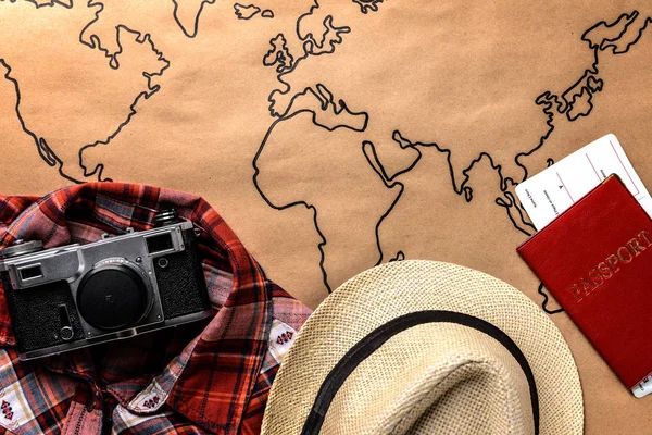 世界地图上的衣服、照片摄像头、护照和门票。旅游理念 — 图库照片