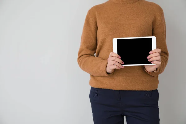 Young businesswoman with tablet PC on light background — Stock Photo, Image