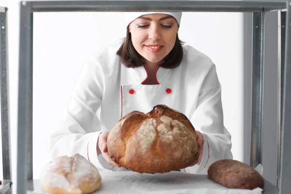 Female chef with freshly baked bread in kitchen — Stock Photo, Image