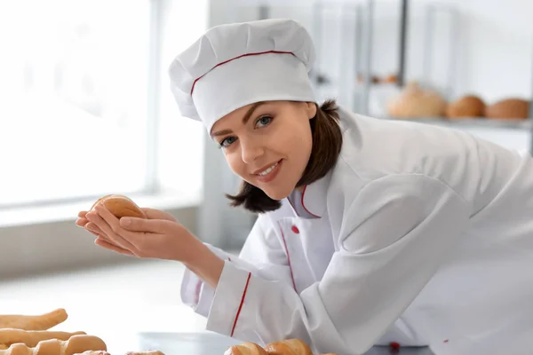 Женский шеф-повар со свежеиспечённой выпечкой на кухне — стоковое фото