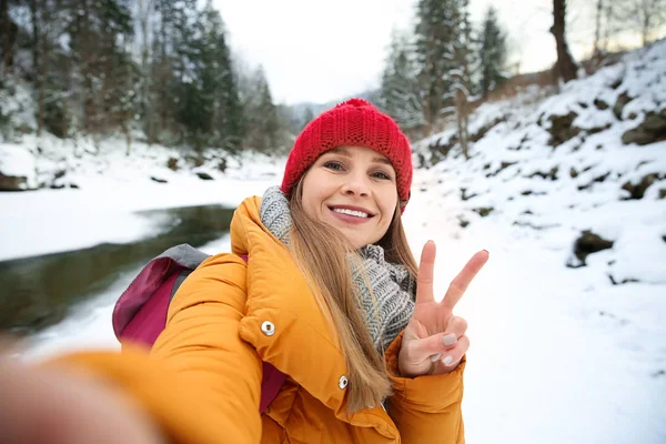 Beautiful woman taking selfie at snowy resort — Stock Photo, Image